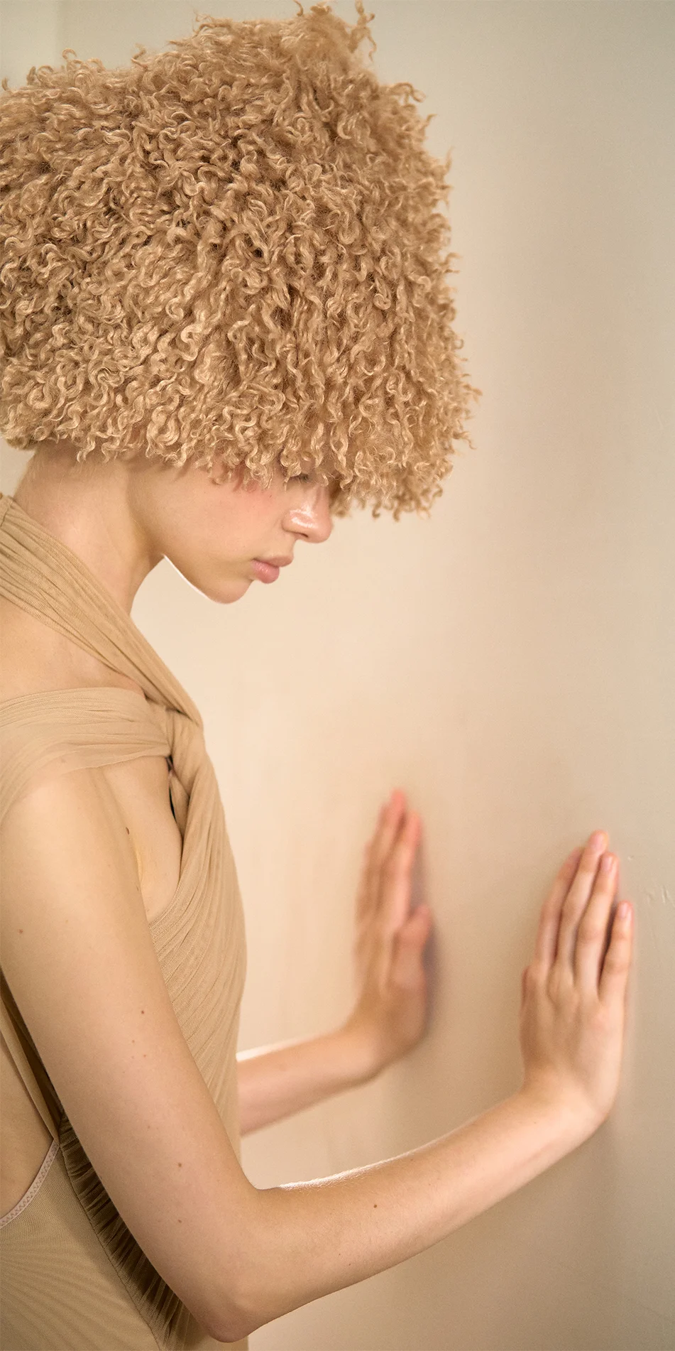 Faux fur hat neck warmer nude side view with hands on the wall