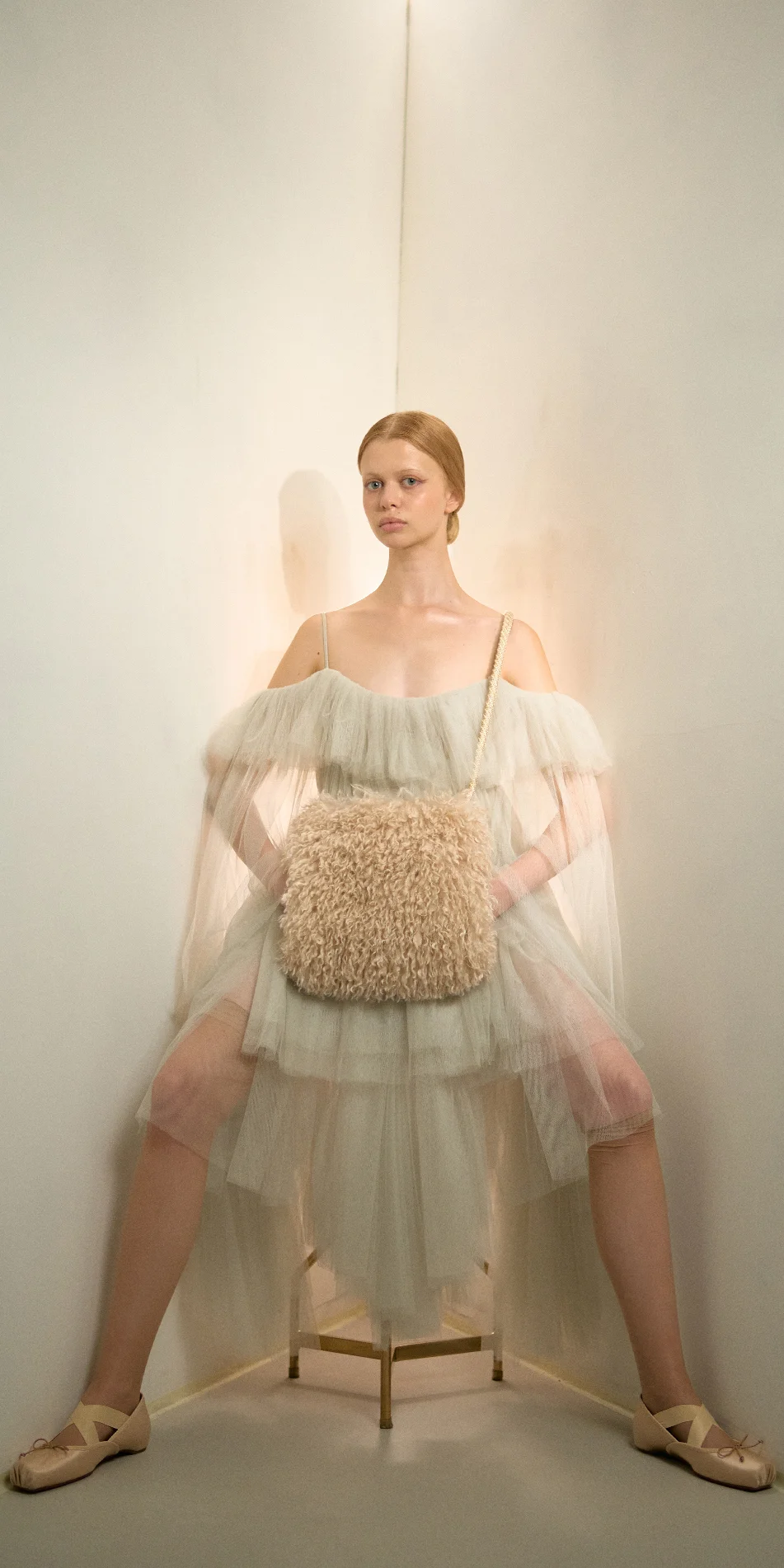 Faux fur muff crossbody bag light beige sitting on