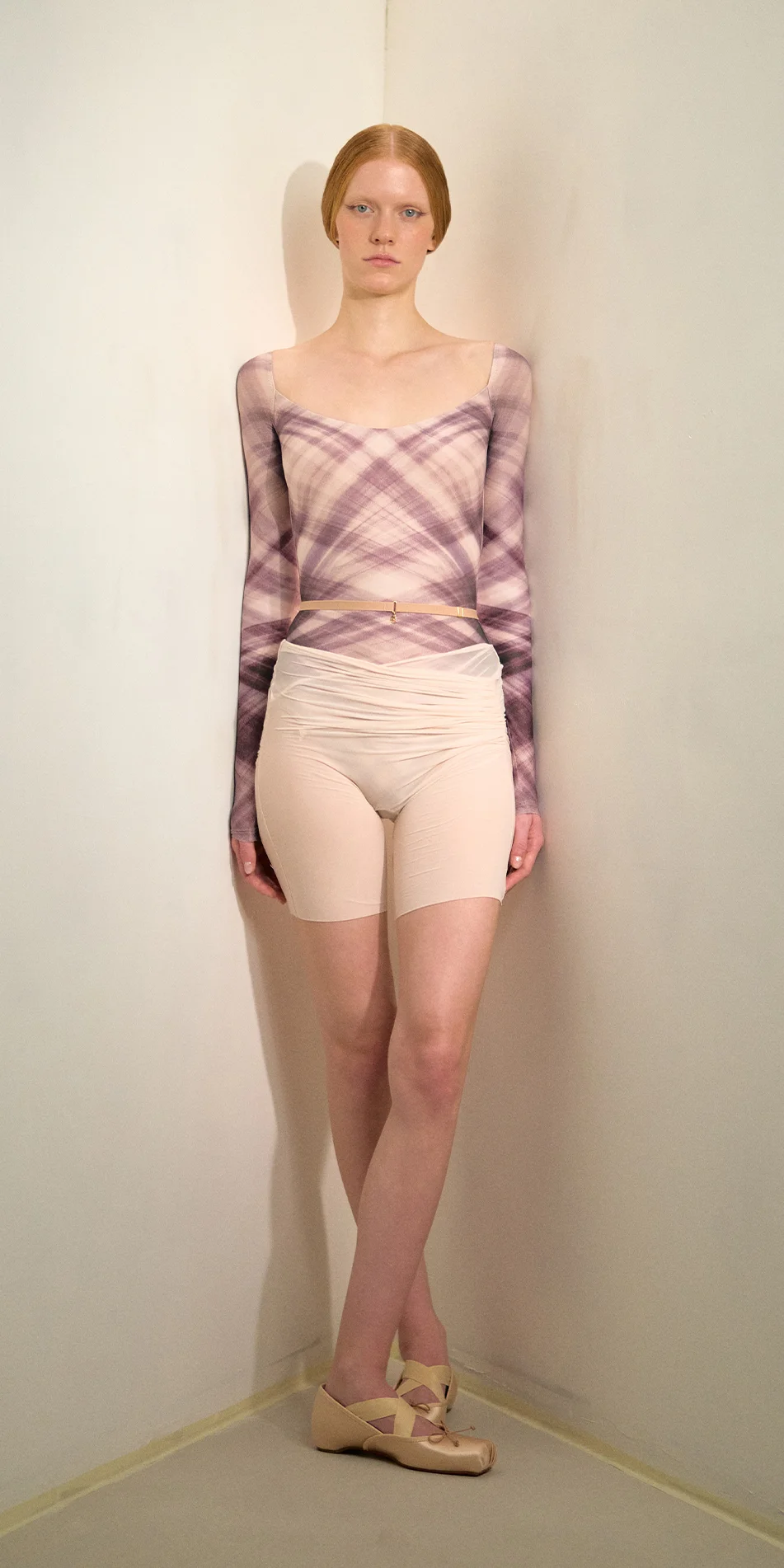 Sheer bike shorts in soft pink front legs crossed on
