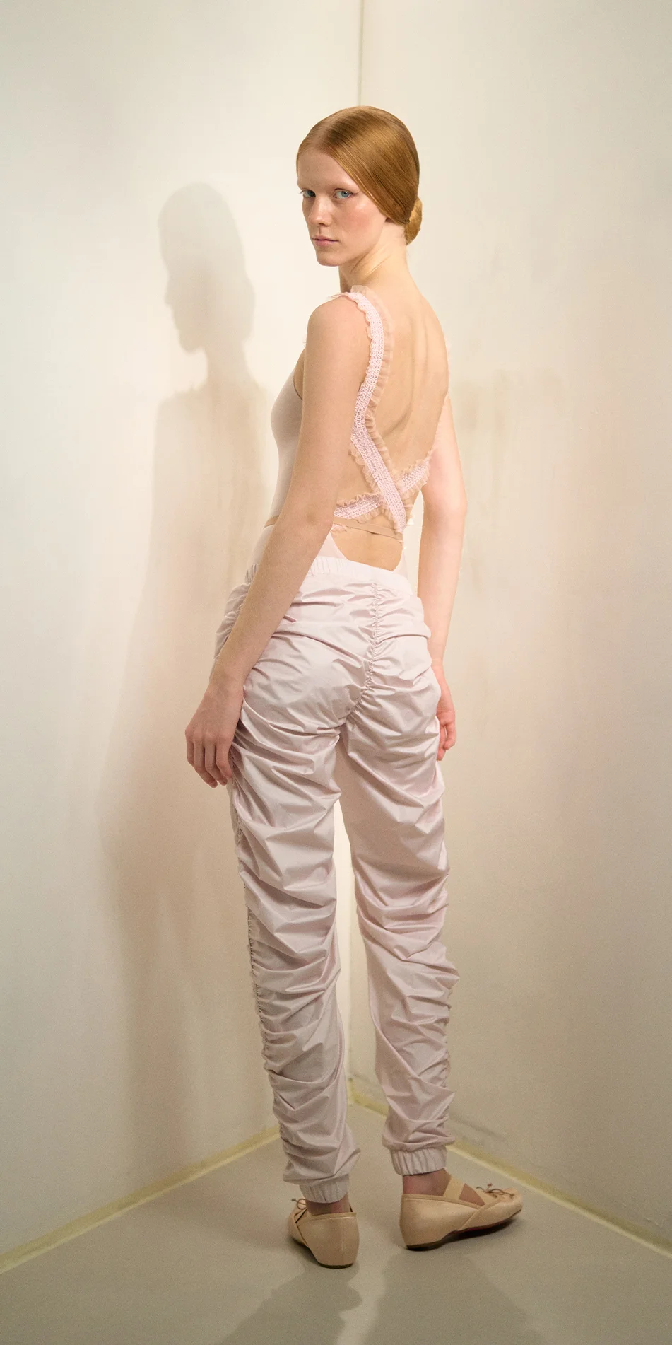 Womens draped track pants in soft pink back view look back