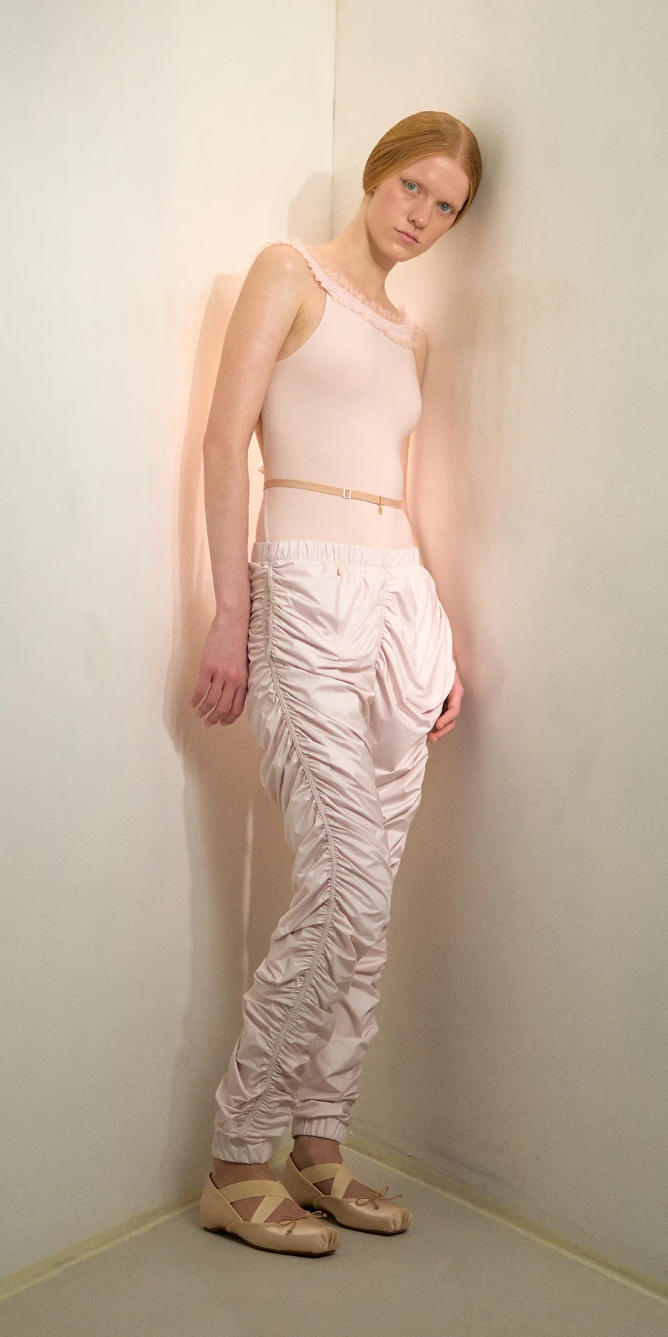 Womens draped track pants in soft pink front side on