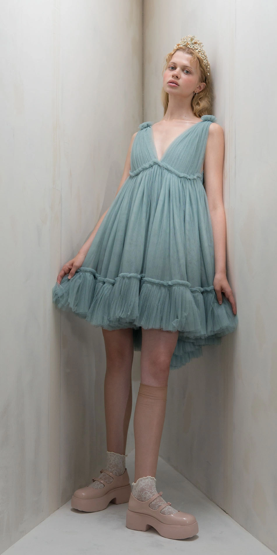 Tulle split neck babydoll dress in light blue front leaning against wall