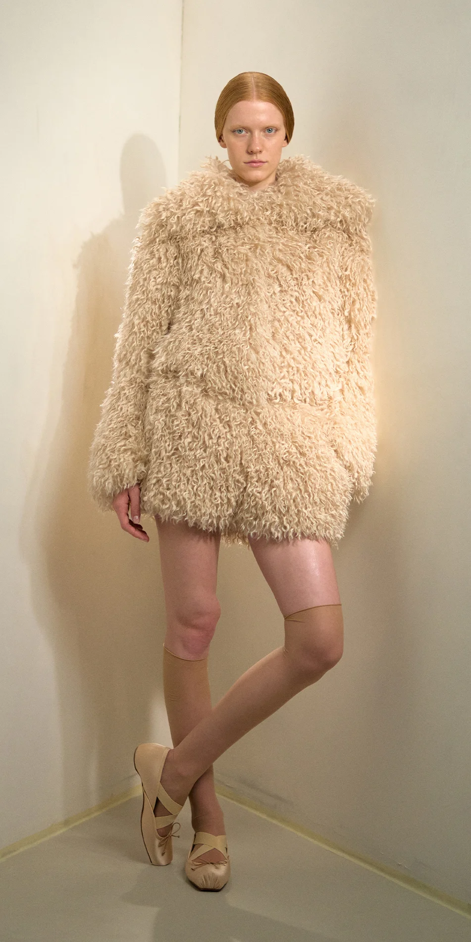 Faux fur jacket light beige front view crossed legs