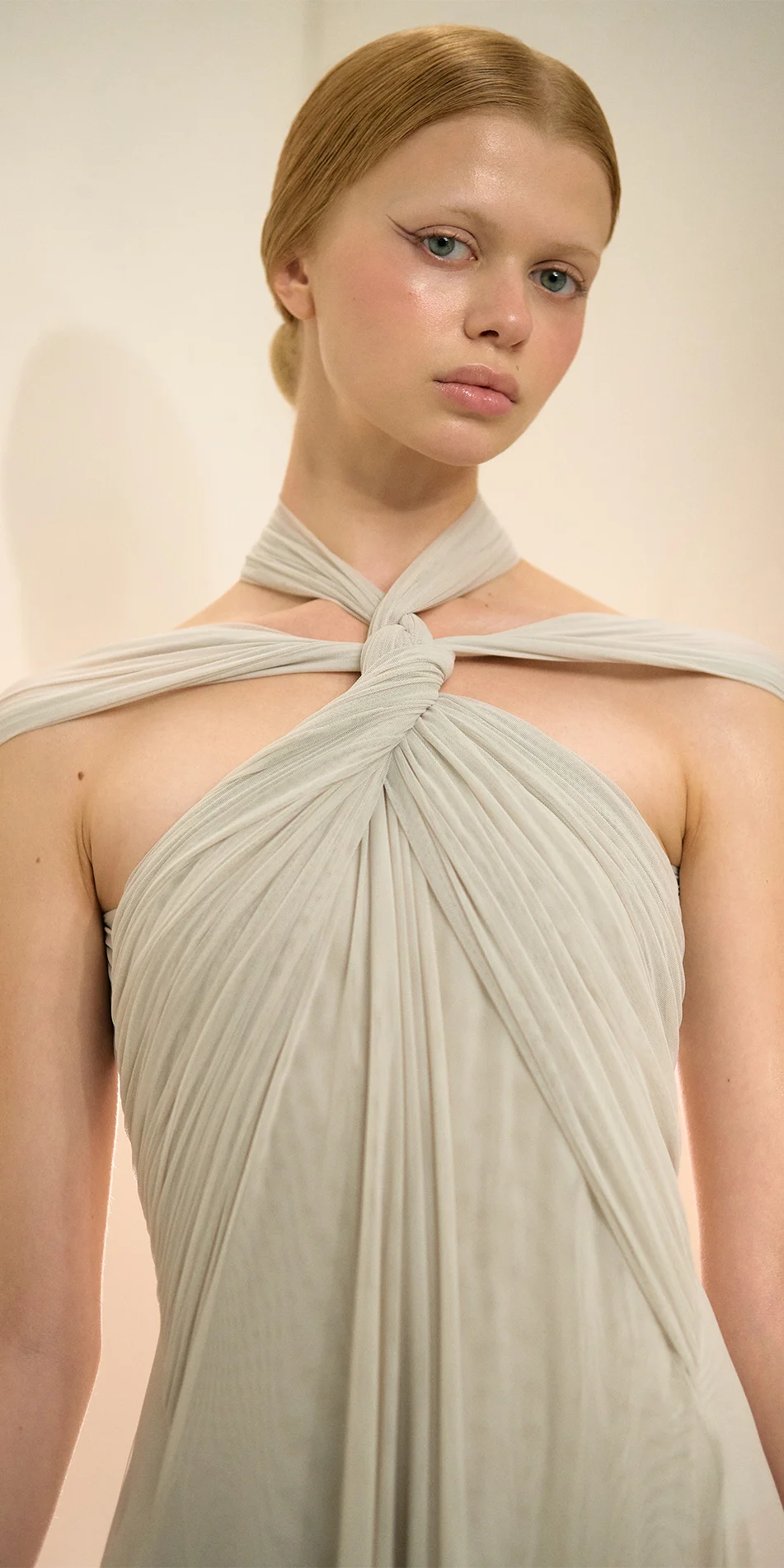 Knotted halter maxi dress in sage green crop of upper body with model looking down