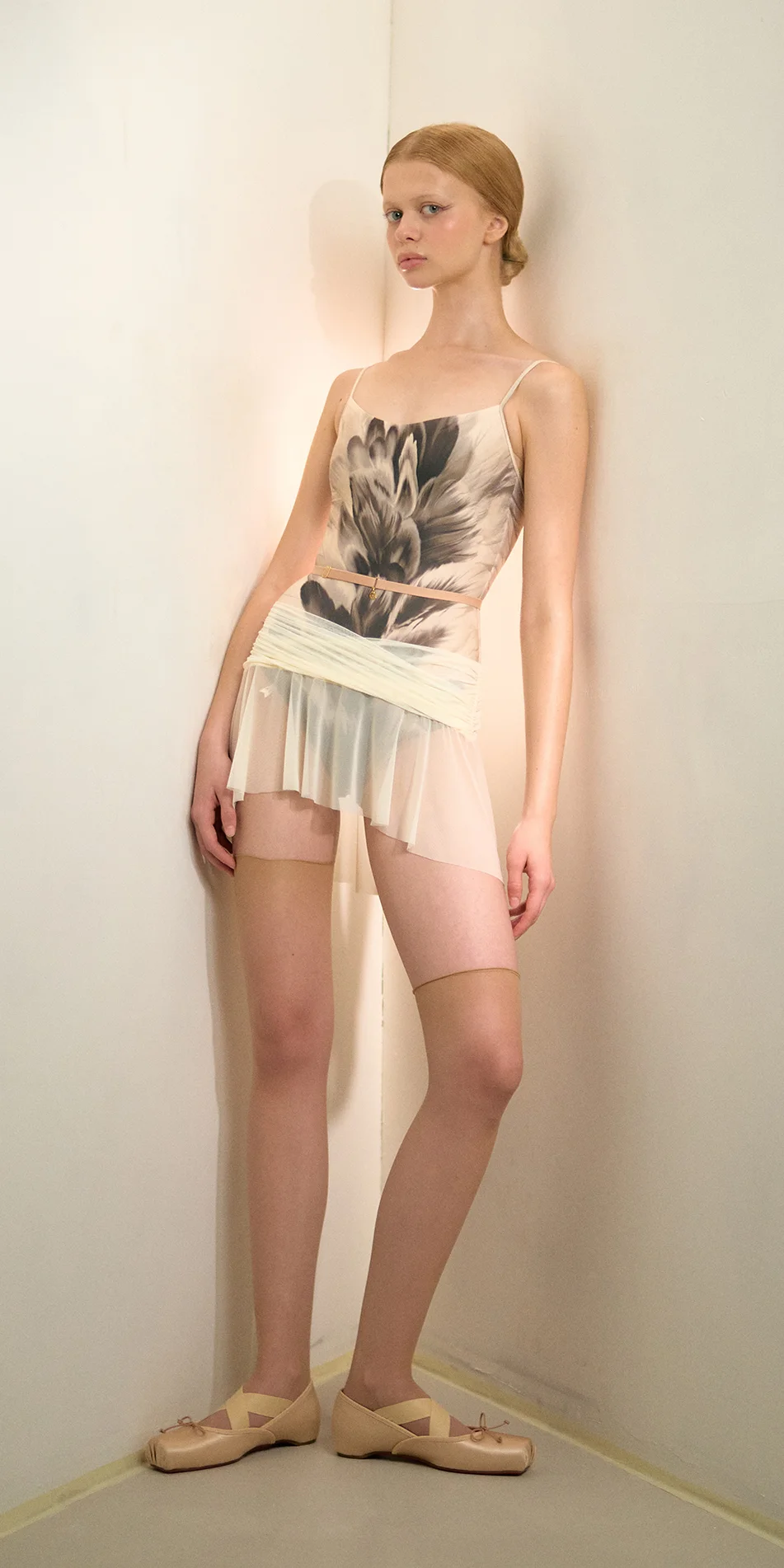 Mesh mini skirt in cream front leaning on