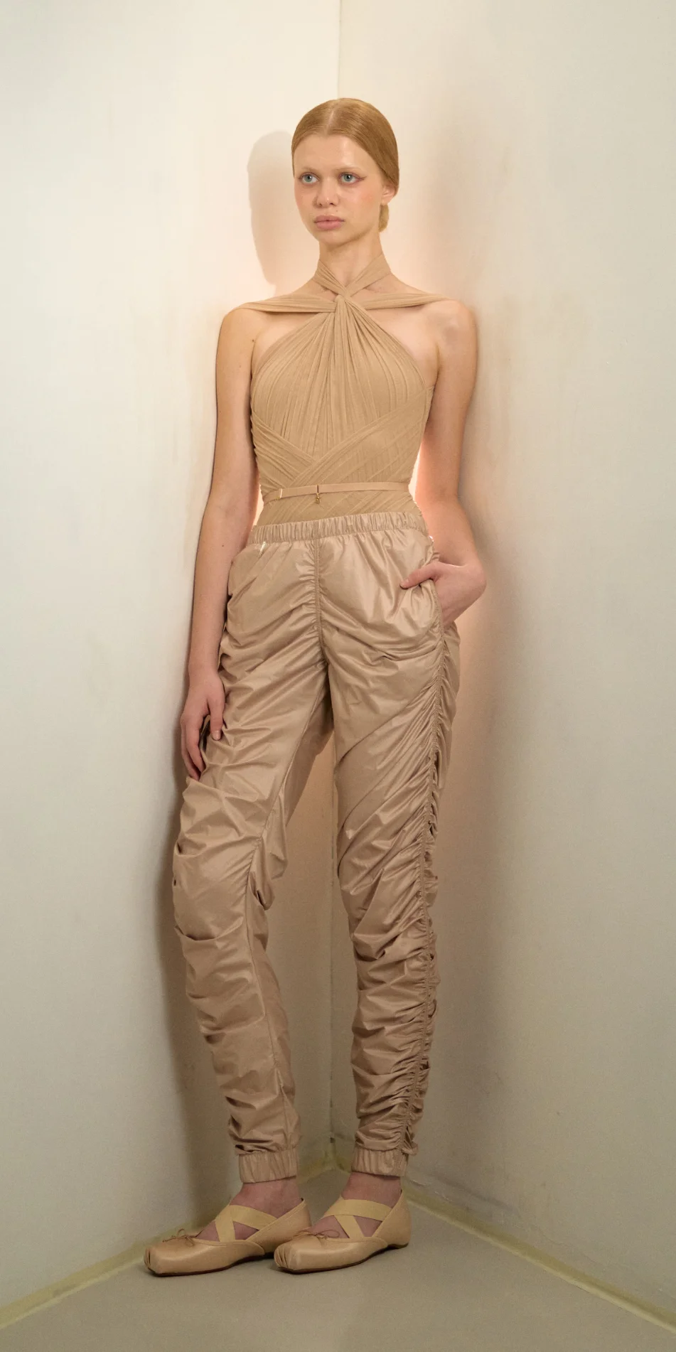 Womens draped track pants in light beige front hand in pocket on