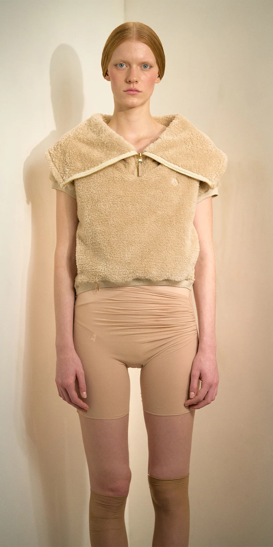 Zip neck fleece vest in light beige front arms down on